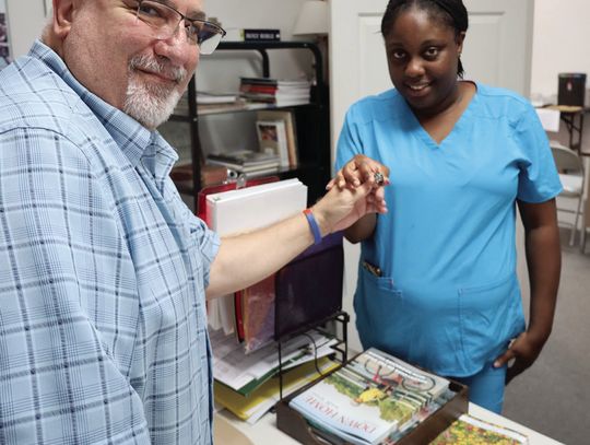 Publisher Dave Shabaz hands the lost class ring of Culberson Williams to his niece, Jasmine Mathis. Williams, who has leukemia, lives in Austin and his family will visit him with the ring. STAFF PHOTO