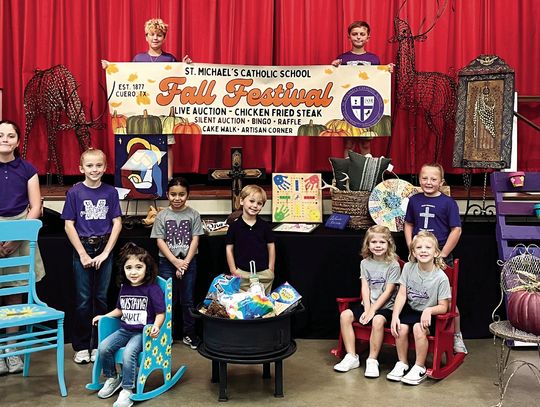 The students of St. Michael’s Catholic School hold a chair just for you at the Fall Festival on Sunday, Oct. 27. (Front Row, L-R)) Lenny Boehl, Ana Pacheco, Cora Zimmerman, Halle Zimmerman, and Alice Adams (Middle Row, L-R) Lillyanne Hance, Landrey Koopmann, Reese Corpus, Kade Vackar, Bayl...