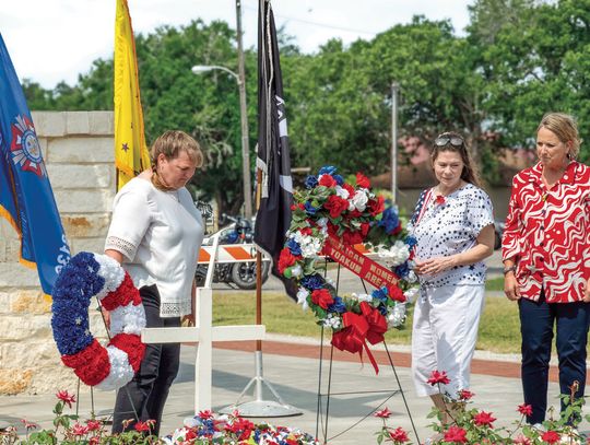 Members of the VFW Auxiliary Post 8136, from left, Valerie Chinnery, Heather Menn, and Laura Wauson lay the wreaths honoring the fallen dead at the May 26 Memorial Day Ceremony. PHOTO BY ELE CHEW