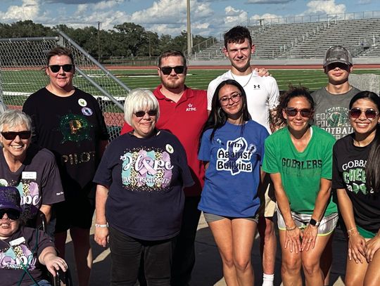 Members of the Pilot Club and Anchor Club share a moment at the awareness walk as part of Suicide Prevention Month. (Staff Photo)