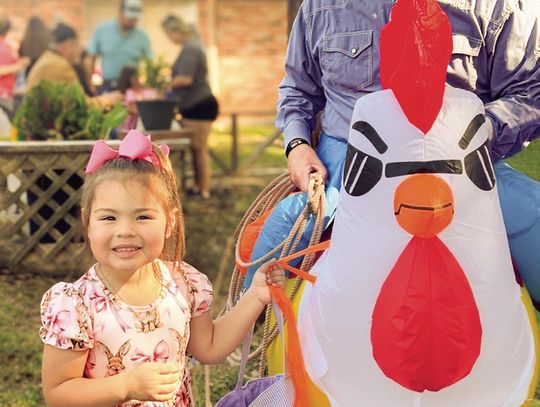 Annie Naranjo (L-R) shows her Easter egg basket to Yorktown Lions Club President Elect Mark Black aka Rowdy Rooster at Yorktown Community-Wide Easter Egg Hunt on April 12. PHOTOS BY KATIE NEWMAN