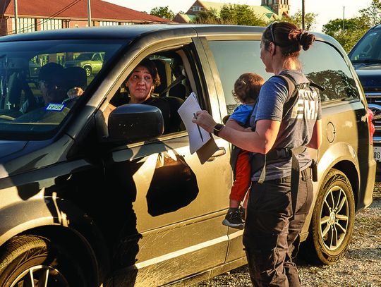 Executive Director Terri Rogers, with a baby on her back, checks the orders. PHOTO BY ELE CHEW