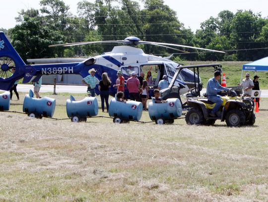 A four-wheeler train cruises past the Lifeflight helicopter at Saturday’s 2nd Annual Touch -A-Truck at the Cuero VFW, sponsored by the Friends of DeWitt County Children. (Staff photos)