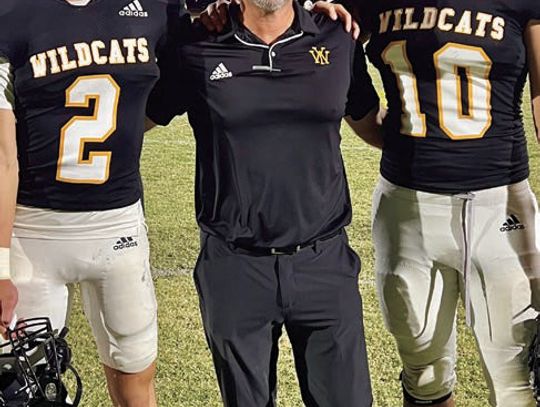 Yorktown Head Coach Ryan Knostman has both his sons on varsity this year: sophomore Brayden, left, and junior, Ryan Jr., on right. The Wildcats dealt a heavy blow to district foe, Charlotte, 56-0, on Oct. 18. PHOTO BY DEIRDRE ALEXANDER