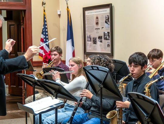 Band Director Larry Barnett led the Yorktown Wildcat Christmas Ensemble in Frosty the Snowman and Rudolph the Red-Nose Reindeer that warmly cheered the room. (Photo by Ele Chew)