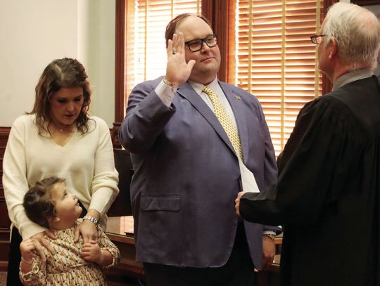 Brian Cromeens, the new 24th Judicial District Attorney, takes the oath of office on January 1 accompanied by his wife, Maggie, and daughter Libby. District Judge Stephen Williams administered the oath. STAFF PHOTO