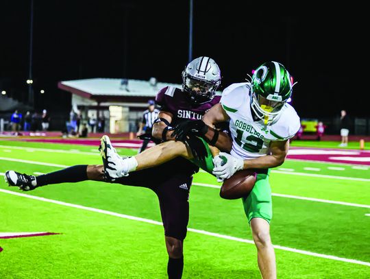 Walker Dietze tries to control the ball in the Sinton matchup. (Photo by Mike Cantu)
