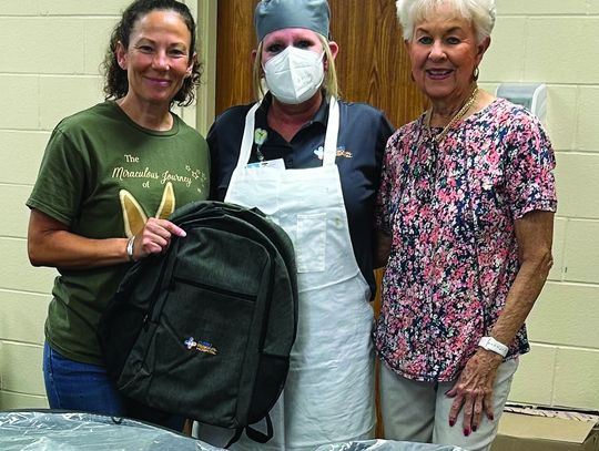 The Cuero Regional Hospital Volunteers handed out backpacks to all hospital employees on July 26. Pictured are Pam Lester, coordinator for the project and Emily Davis, treasurer of the group, presenting a backpack to hospital employee Wendy Barbontin.