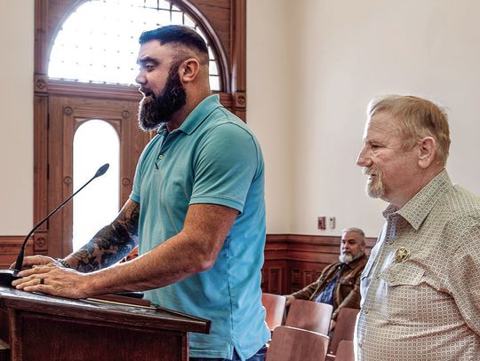 Adam Fanning, left, with Brandt Companies, and Sheriff Carl Bowen, right, present a report to the Commissioners Court regarding the jail’s failing hot water heaters. PHOTO BY ELE CHEW