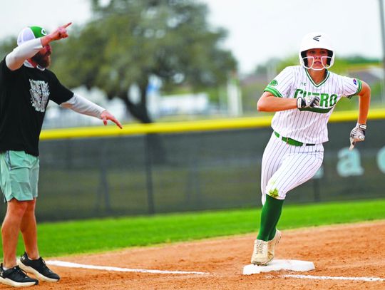Caroline Kubesch rounds third base as Coach Cody Miller moves her onto home during the district match up with Gonzales on March 25. The Lady Gobblers won the game 6-3. (Photo by Courtney Kubesch)