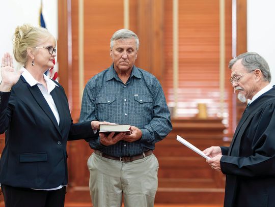 Judge Daryl Fowler swears in Lindsay Renee Ruppert as Justice of the Peace for Pct. 1 with her husband, Jeff, holding the Bible on May 28, at the DeWitt County Courthouse. (Photo by Ele Chew)