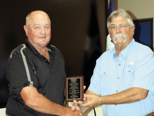 Robert Moore receives a plaque from Board President Johnny Jank for his 30 years of service to Meyersville education (Staff photo)