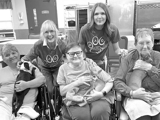 Pet Adoptions of Cuero Ambassadors Lizzie Rosson and Camryn Lake share some puppy love with residents at Cuero Nursing and Rehab. Both the residents and the puppies enjoyed the extra affection. (Contributed Photo)