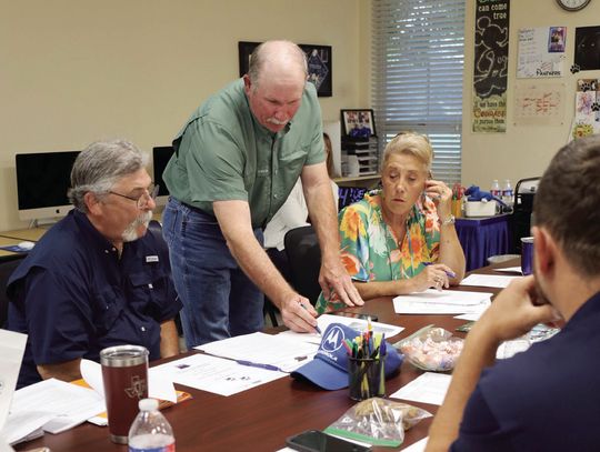 Precinct 4 County Commissioner Brian Carson looks over plans for road work in front of the Myersville School during the district’s board meeting on May 6. Carson attended the meeting to share the plans that the county has for widening the Myersville Road in 2026. Board members decided to c...