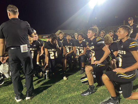 The Wildcats take a knee to listen to Coach Ryan Knostman after their final district game against Shiner. PHOTO BY DEIRDRE ALEXANDER