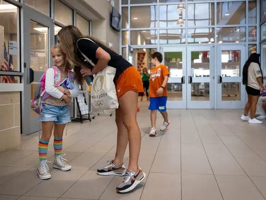 Matilda Shaefer gets a goodbye kiss from her mom Allyson as she heads to class at Timber Lakes Elementary School in Splendora on Aug. 29, 2024. Credit: Annie Mulligan for The Texas Tribune