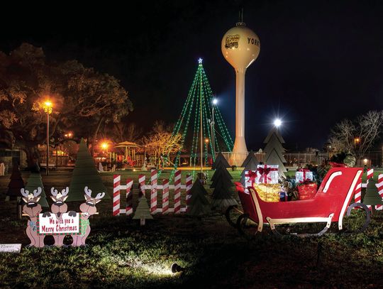 The 25-foot lighted pole tree is the newest addition to the Christmas Park Project. The Frankie Seifert family donated a sleigh, which was repainted and decorated with green wooden fir trees made by Connie Hall and Rene Alvarez. PHOTOS BY ELE CHEW
