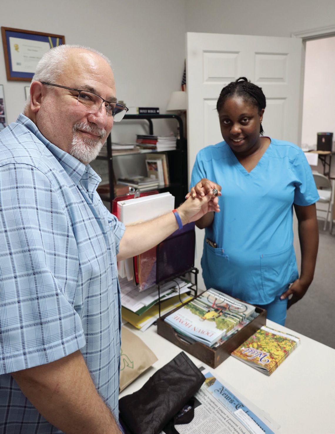 Publisher Dave Shabaz hands the lost class ring of Culberson Williams to his niece, Jasmine Mathis. Williams, who has leukemia, lives in Austin and his family will visit him with the ring. STAFF PHOTO