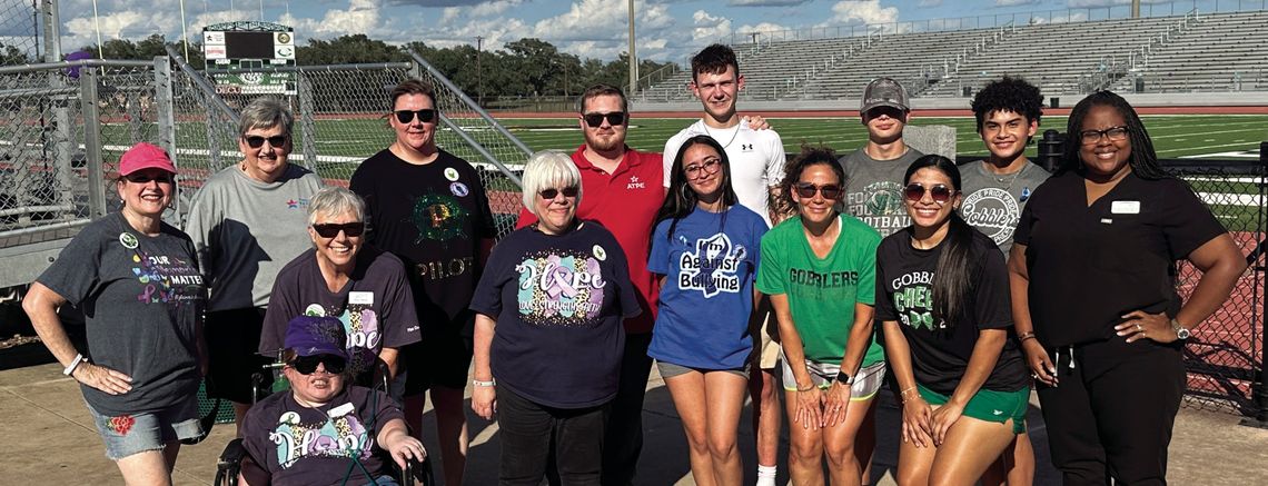 Members of the Pilot Club and Anchor Club share a moment at the awareness walk as part of Suicide Prevention Month. (Staff Photo)