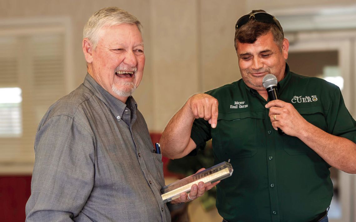 Mayor Emil Garza jokes that, instead of a trip to Ireland, the city presents a crystal plaque to retiring council member Bill Matthys in recognition of his contributions. (Photo by Ele Chew)
