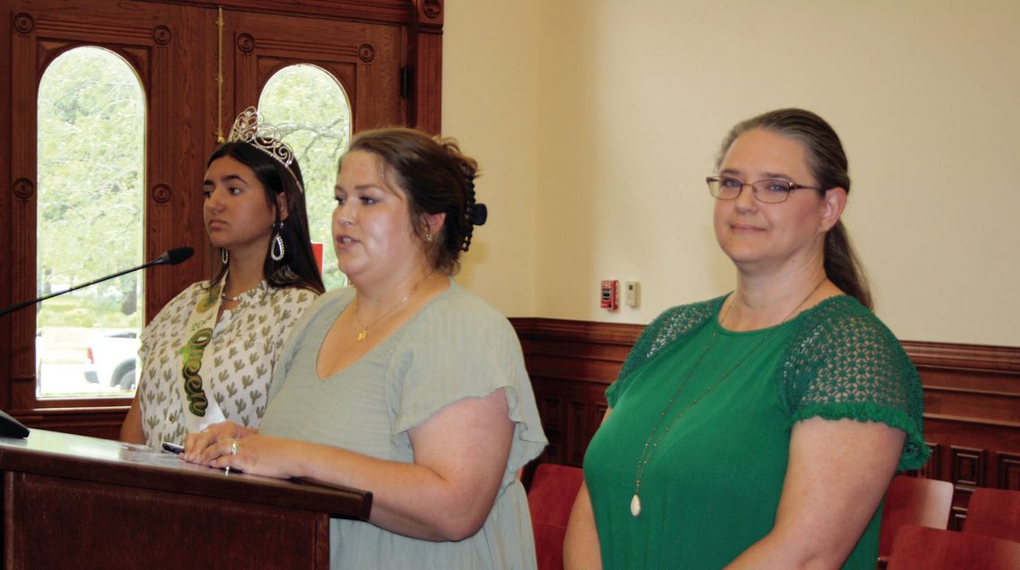 County 4-H Extension Agent Candace Williams, center, speaks to the Commissioner’s Court on July 12, sharing the special honor presented to Amanda Cowey, right, at the State 4-H Roundup. Cowey received the Salute to Excellence for her many years of 4-H volunteer service, including the Cuero...