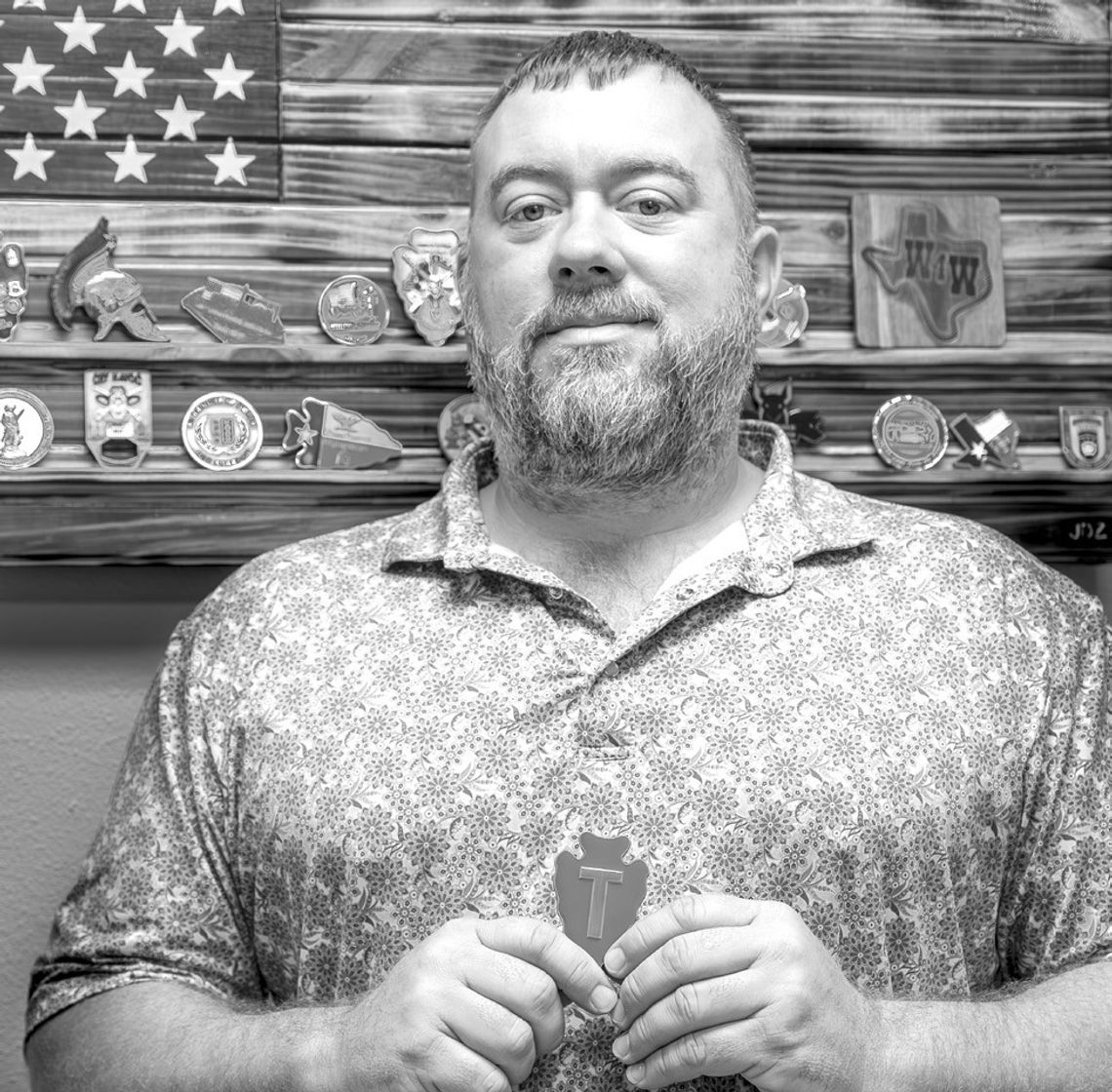 Zengerle holding up 36th ID Coin. The arrowhead shape represents Oklahoma and the “T” for Texas. This patch (Division) spanned from Texas through Oklahoma.