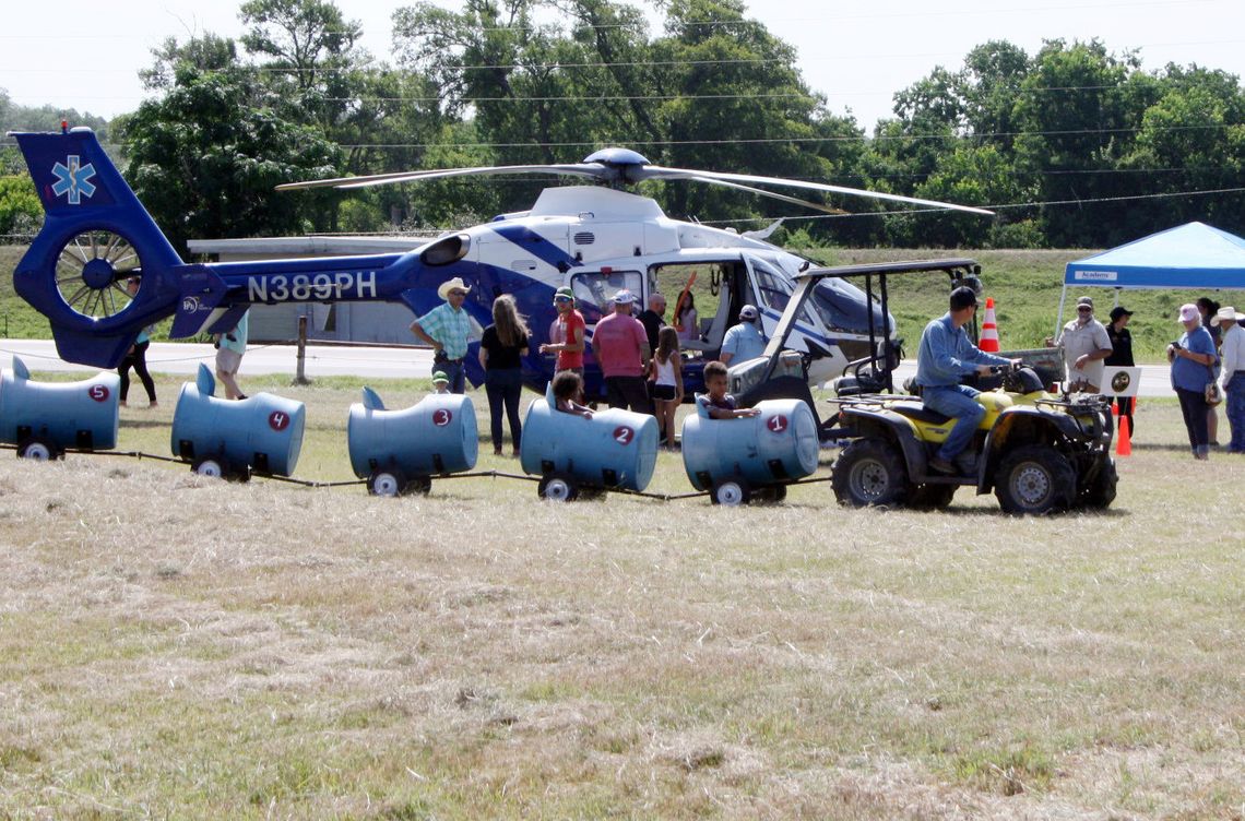 A four-wheeler train cruises past the Lifeflight helicopter at Saturday’s 2nd Annual Touch -A-Truck at the Cuero VFW, sponsored by the Friends of DeWitt County Children. (Staff photos)