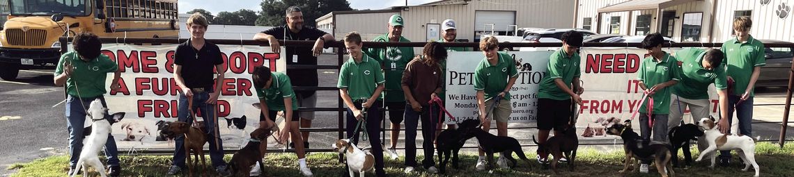 The Gobbler football team visit Pet Adoptions of Cuero on Thursday, Aug. 29, to walk all the big dogs. A parade of green shirts led a dozen dogs at one time down Highway 183 in front of the shelter. (Contributed photo)