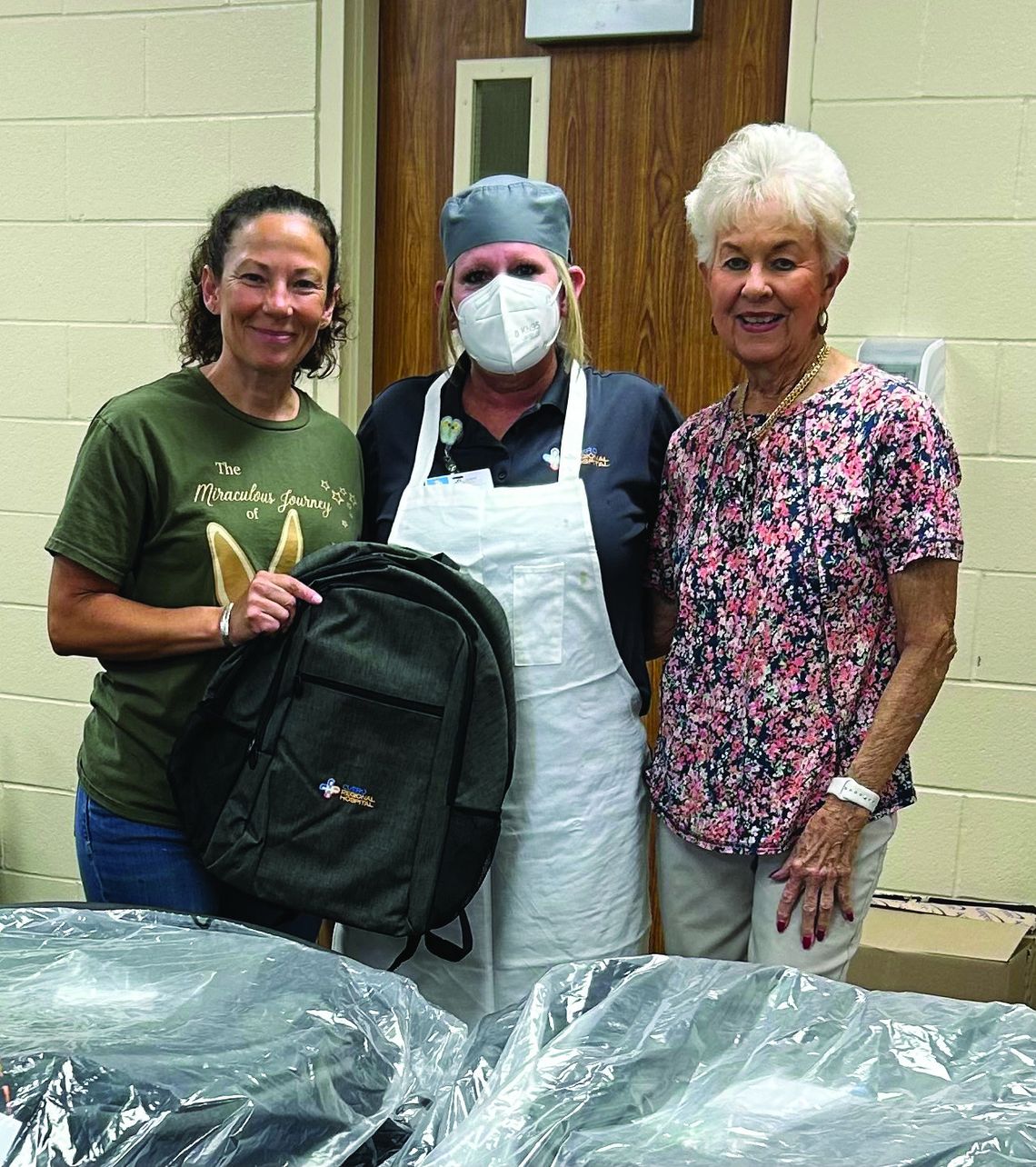 The Cuero Regional Hospital Volunteers handed out backpacks to all hospital employees on July 26. Pictured are Pam Lester, coordinator for the project and Emily Davis, treasurer of the group, presenting a backpack to hospital employee Wendy Barbontin.