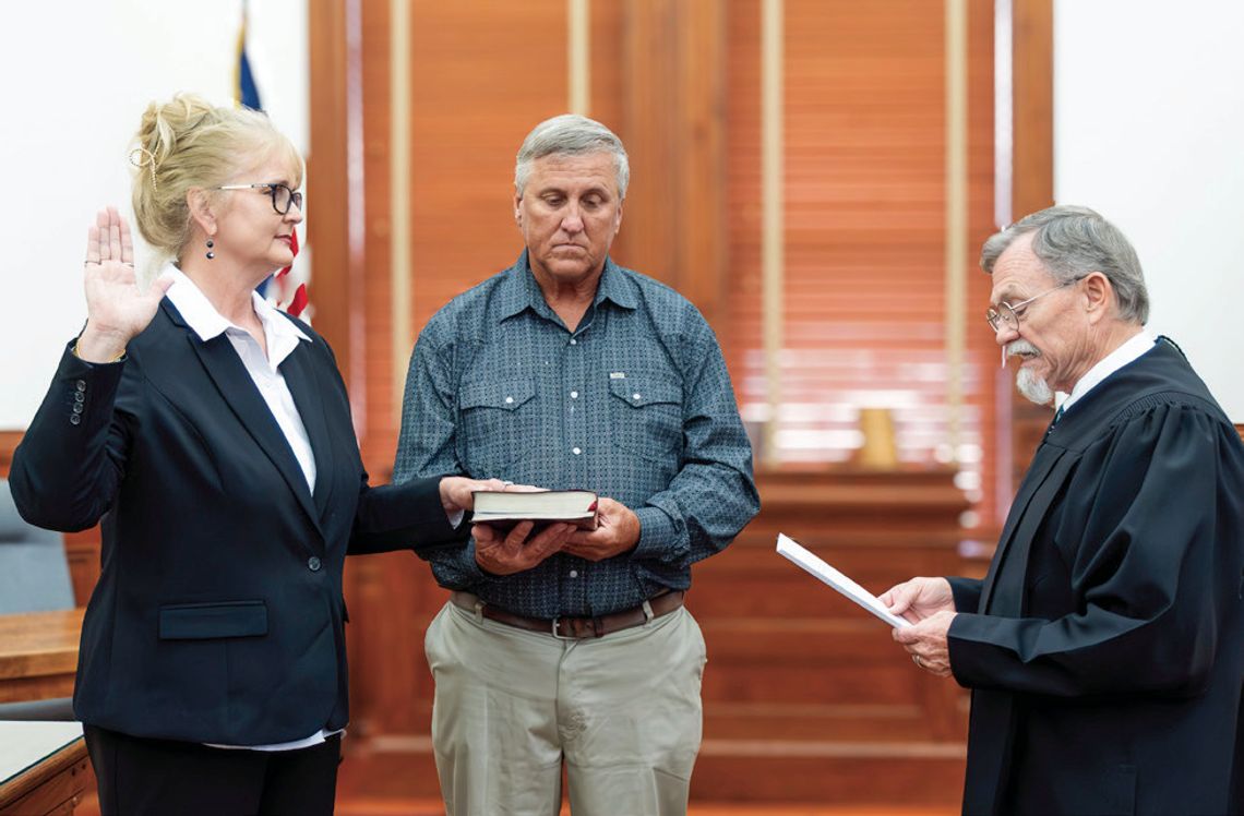 Judge Daryl Fowler swears in Lindsay Renee Ruppert as Justice of the Peace for Pct. 1 with her husband, Jeff, holding the Bible on May 28, at the DeWitt County Courthouse. (Photo by Ele Chew)