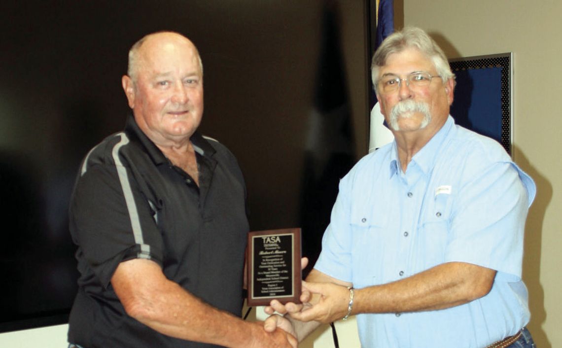 Robert Moore receives a plaque from Board President Johnny Jank for his 30 years of service to Meyersville education (Staff photo)