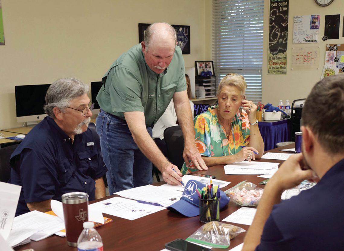 Precinct 4 County Commissioner Brian Carson looks over plans for road work in front of the Myersville School during the district’s board meeting on May 6. Carson attended the meeting to share the plans that the county has for widening the Myersville Road in 2026. Board members decided to c...