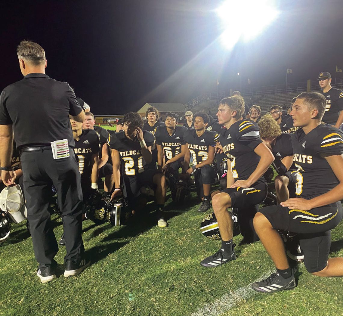 The Wildcats take a knee to listen to Coach Ryan Knostman after their final district game against Shiner. PHOTO BY DEIRDRE ALEXANDER
