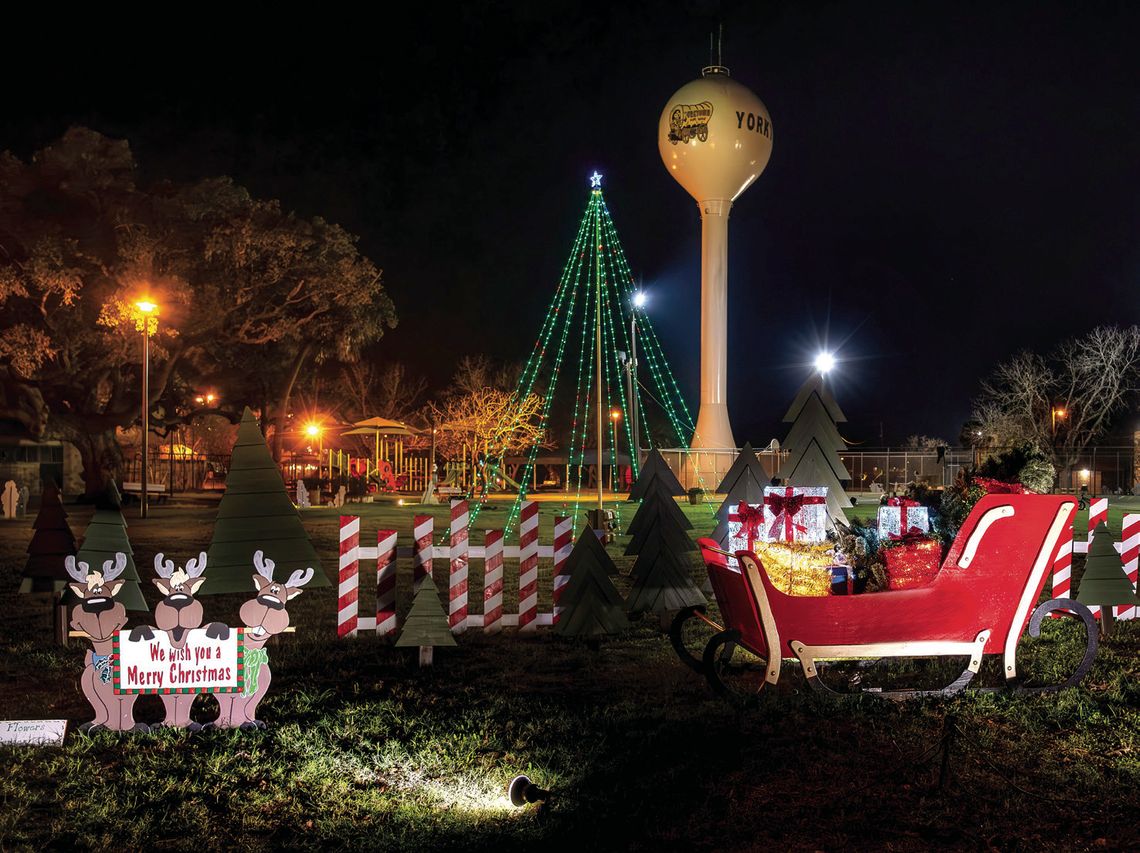The 25-foot lighted pole tree is the newest addition to the Christmas Park Project. The Frankie Seifert family donated a sleigh, which was repainted and decorated with green wooden fir trees made by Connie Hall and Rene Alvarez. PHOTOS BY ELE CHEW
